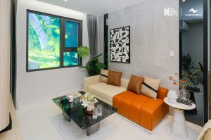 Nhà mẫu căn hộ Studio The Win City – phòng khách với sofa và cửa sổ view cây xanh